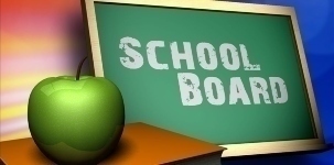 Image of Apple on table next to chalk board that has School Board written on it